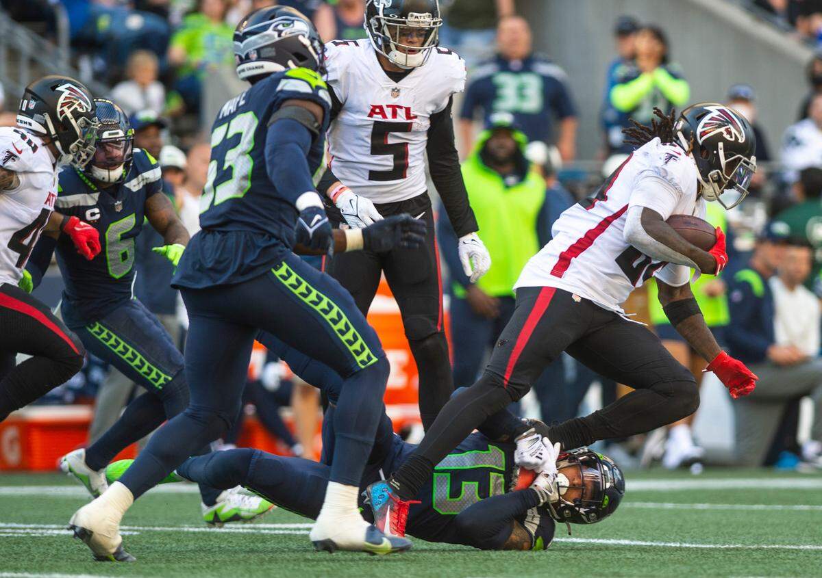 Seattle Seahawks strong safety Josh Jones (13) tackles Atlanta Falcons running back Cordarrelle Patterson (84) by grabbing his foot in the fourth quarter of an NFL game at Lumen Field in Seattle, Wash. on Sept. 25, 2022. The Seahawks lost to the Falcons 23-27.