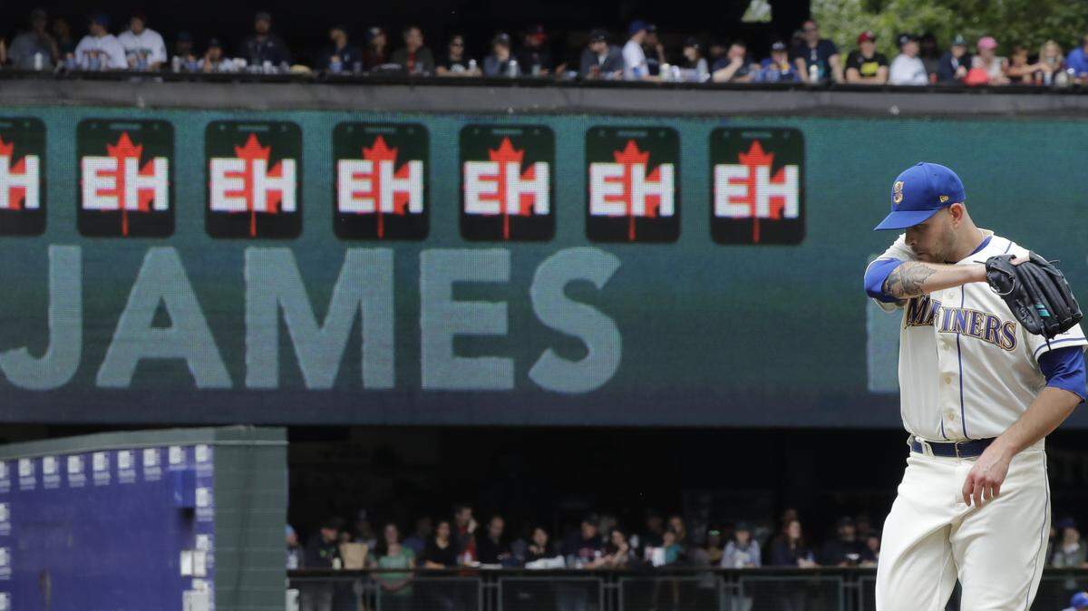 With a video display keeping track of his strikeouts with “Eh” logos, Seattle Mariners starting pitcher James Paxton stands on the mound during a baseball game against the Kansas City Royals, Sunday, July 1, 2018, in Seattle. (AP Photo/Ted S. Warren)