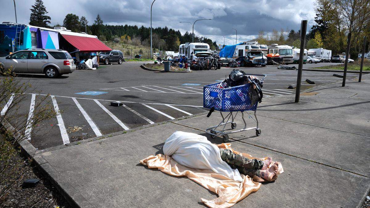 Motorhomes and travel trailers set up in the Pierce Transit Center Street park-and-ride lot bordering state Route 16 in Tacoma on April 19, 2023.