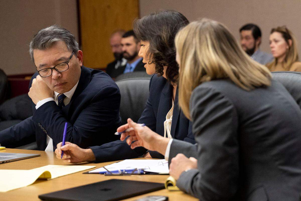 Washington state assistant attorneys general Kent Liu (left) and Patty Eakes (right) talk with state attorney general special assistant Lori Nicolavo (center) during a hearing on the possible rescheduling of the trial of the Tacoma police officers charged with killing Manny Ellis. Photographed on Friday, Dec. 2, 2022, at Pierce County Superior Court in Tacoma.