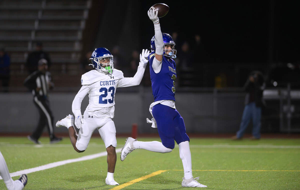 Puyallup wide receiver Jayden Woodland pops into the end zone in front of Curtis defensive back Torry Thomas for a touchdown reception during Friday night’s football game at Sparks Stadium in Puyallup, Washington, Oct. 25, 2024. Puyallup won the game, 49-35.