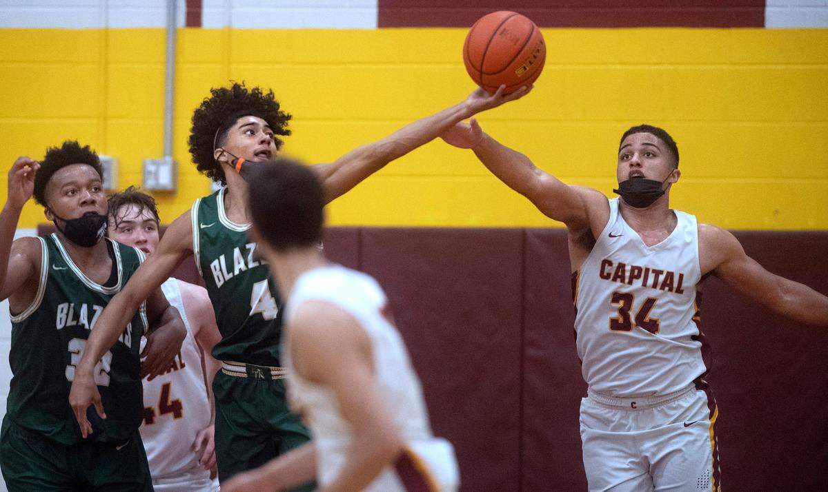 Timberline’s Brooklyn Hicks (4) beats Capital’s Caine Hoffman to a rebound during Thursday night’s 3A SSC league boys basketball game at Capital High School in Olympia, Washington, on Friday, June 11, 2021.
