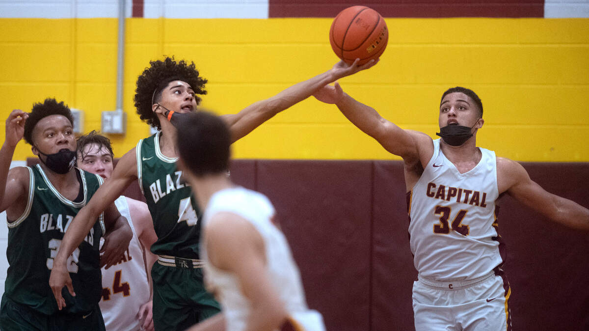 Timberline’s Brooklyn Hicks (4) beats Capital’s Caine Hoffman to a rebound during Thursday night’s 3A SSC league boys basketball game at Capital High School in Olympia, Washington, on Friday, June 11, 2021.