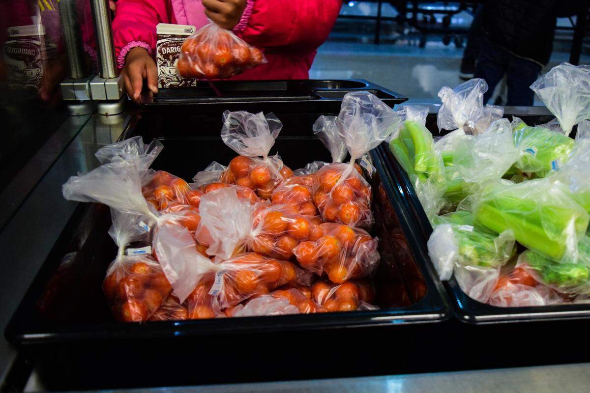 At Spanaway Elementary School outside Tacoma, Wash., a student picks up a bag of cherry tomatoes at lunch on Oct. 20, 2021. Pandemic supply issues have altered how school districts are prepping and packaging food.
