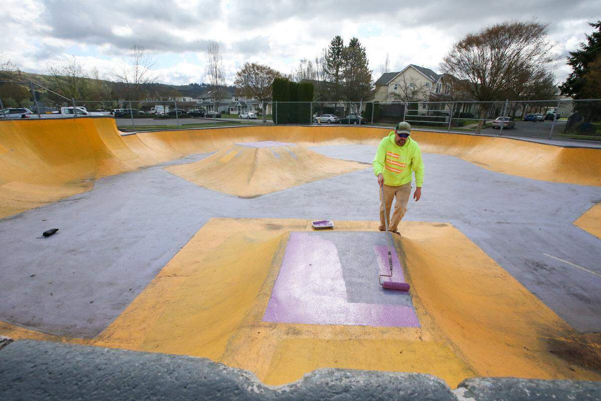 Todd Baginski, parks groundskeeper for the city of Sumner, paints over graffiti at the skate park in the Daffodil Valley Sports Complex on Wednesday, March 30.