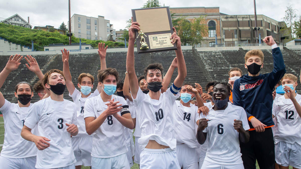 Wilson High’s Connor Tollan holds the 3A Pierce County League soccer championship trophy aloft as his teammates cheer following the Rams’ 2-0 victory over Stadium Saturday, May 1, at Stadium High School.