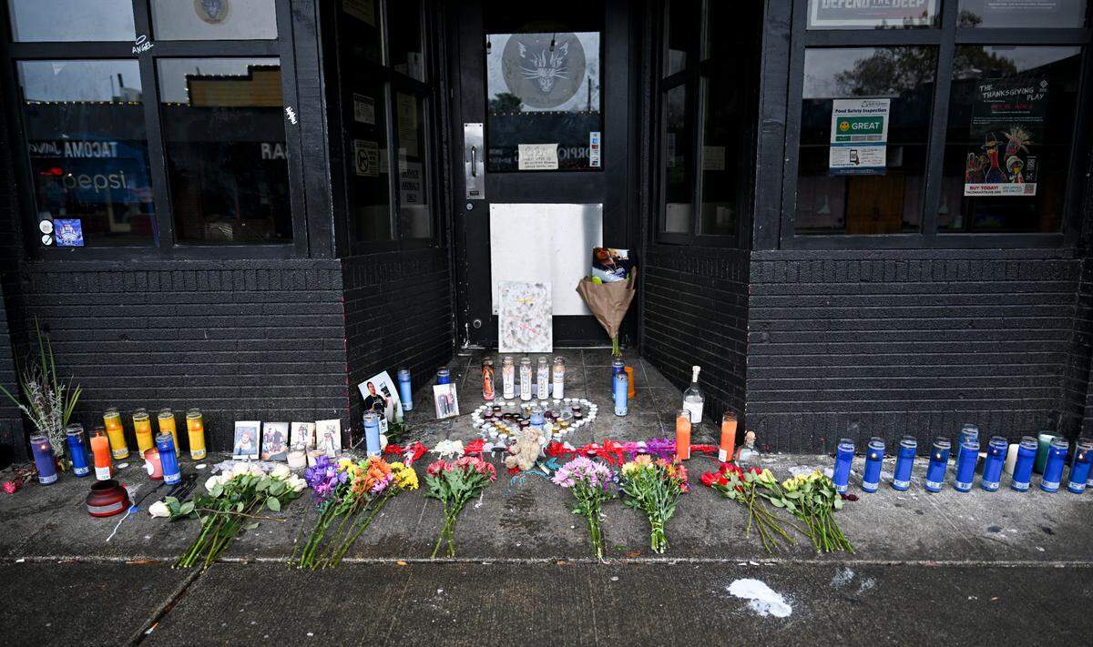 A candle memorial is set up at the site of a shooting that occurred on Sunday morning and left two dead and three injured, at the Alleycat on 6th Avenue, Monday, Nov. 6, 2023, in Tacoma, Wash.