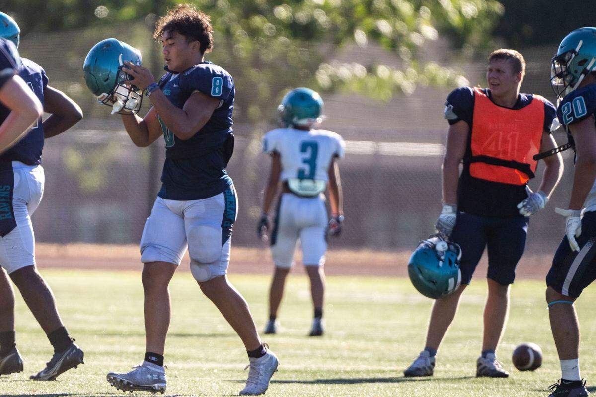 Auburn Riverside running back Thyrou Umi-Tuato’o (8) gets ready for team drills after a water break on Monday, Aug. 22, 2022, at Auburn-Riverside High School in Auburn, Wash.