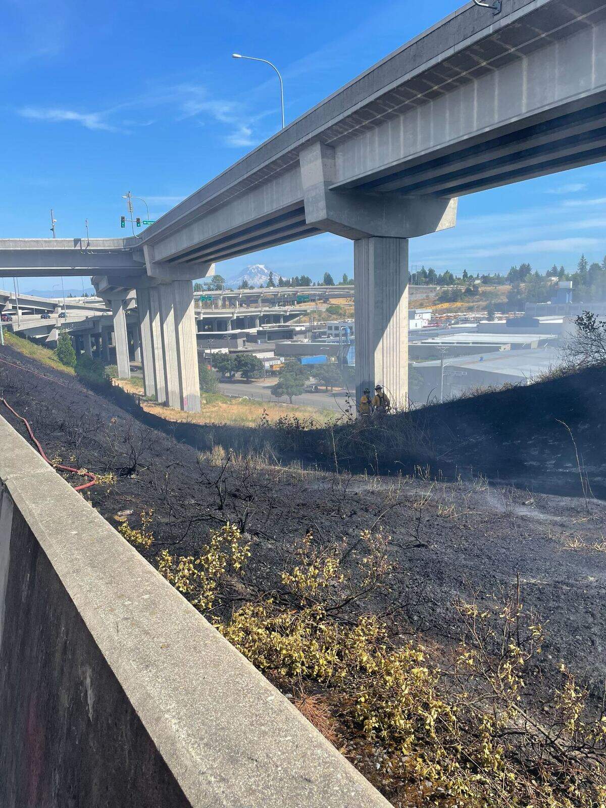 Crews work on putting out a brush fire near the Sprague exit of State Route 16 on July 19, 2025.