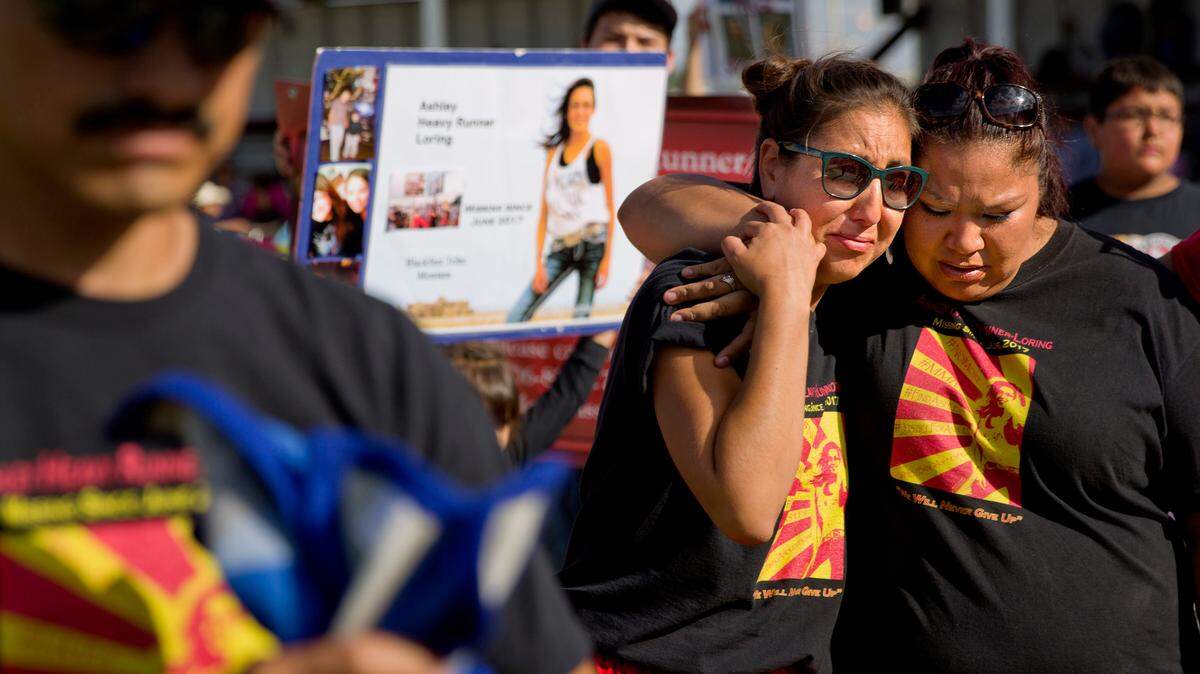 Jenna Loring, left, the aunt of Ashley HeavyRunner Loring, cries with her cousin, Lissa Loring, during a traditional blanket dance at the North American Indian Days celebration in July on the Blackfeet Indian Reservation in Browning, Mont. Ashley went missing in June 2017, and family has searched for her ever since.