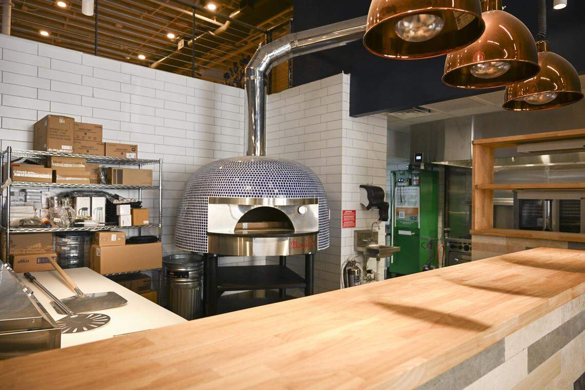 The wood-fired oven remains core to Wooden City’s identity, shown as crews were finalizing details in the new restaurant on April 10.