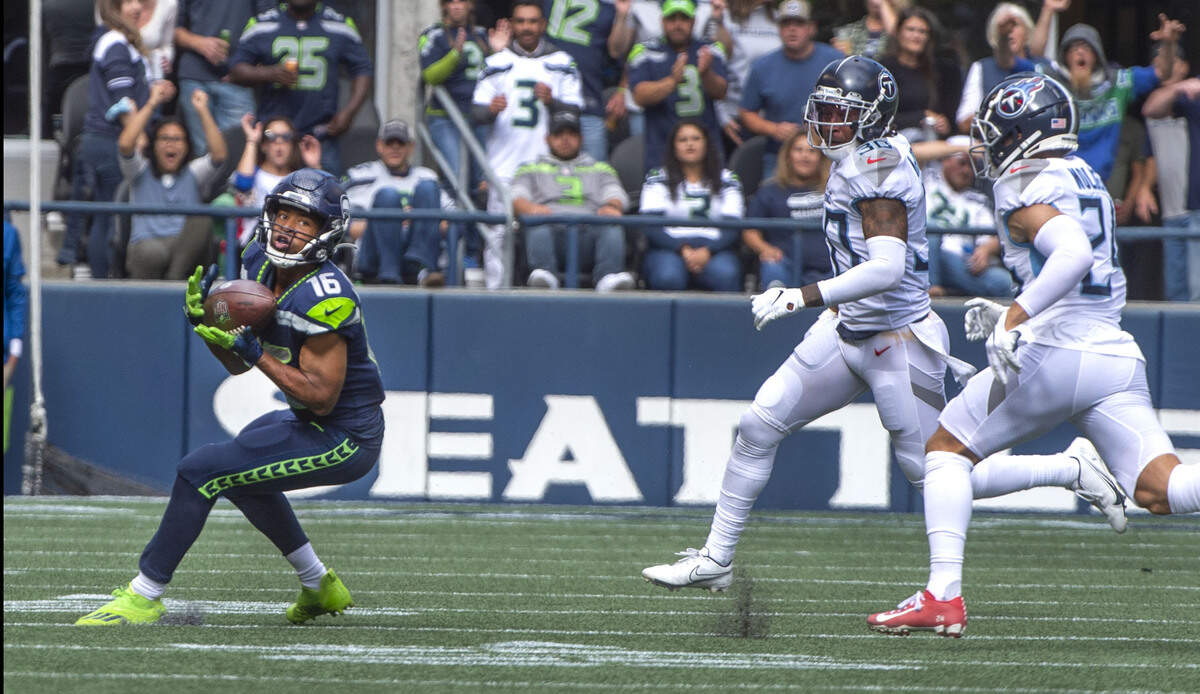Seahawks receiver Tyler Lockett hauls in a pass and eludes Titans defenders Elijah Molden and Bradley McDougald to race in for a 63-yard touchdown in the first half which made the score 9-3 in favor of Seattle at Lumen Field on Sunday, Sept. 19, 2021.