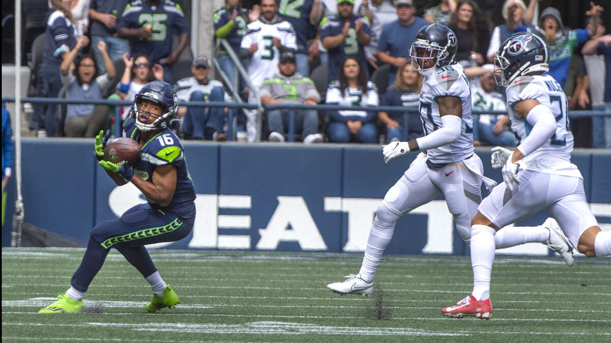Seahawks receiver Tyler Lockett hauls in a pass and eludes Titans defenders Elijah Molden and Bradley McDougald to race in for a 63-yard touchdown in the first half which made the score 9-3 in favor of Seattle at Lumen Field on Sunday, Sept. 19, 2021.