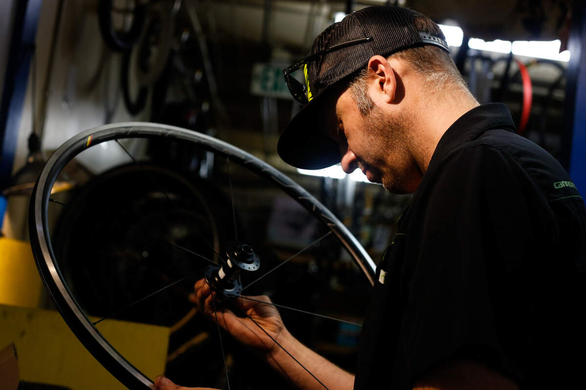 Tory Grant, manager of Old Town Bicylce, puts a bike wheel together in the shop Aug. 10, 2019. Grant said summer is typically the store’s busy season and sees about 50-60 customers a day.