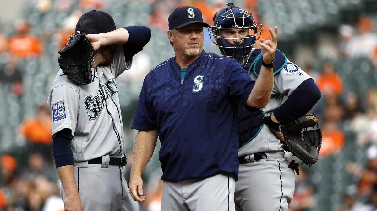 Seattle Mariners pitching coach Mel Stottlemyre, center, motions for manager Scott Servais to come to the mound as he speaks with relief pitcher David Phelps, left, and catcher Mike Zunino in the sixth inning of a baseball game against the Baltimore Orioles in Baltimore, Wednesday, Aug. 30, 2017. Phelps was relieved in the sixth. (AP Photo/Patrick Semansky)