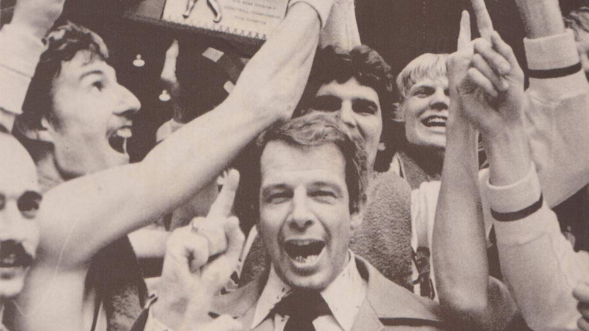 University of Puget Sound basketball coach Don Zech is surrounded by his basketball team holding the NCAA Division II national basketball trophy after they won against Tennessee, 83-70, in Evansville, Indiana on March 19, 1976. (AP file, 1976)