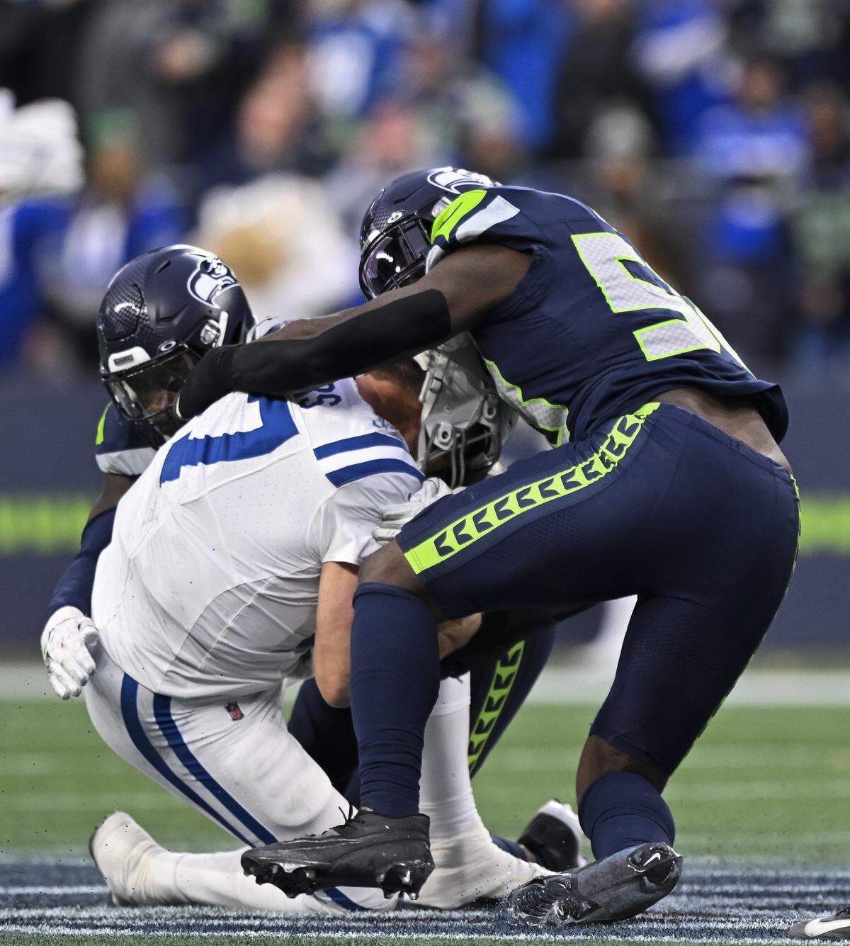 Indianapolis Colts quarterback Philip Rivers (17) is sacked by Seattle Seahawks linebacker Derick Hall (58) and defensive end Demarcus Lawrence (0) during the fourth quarter) of the game at Lumen Field, on Sunday, Dec. 14, 2025, in Seattle.