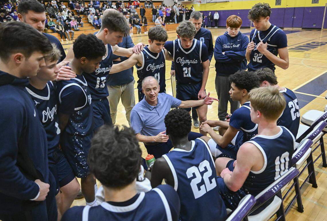 Olympia head coach John Kiley huddles with players during a game against Puyallup on Thursday, Jan. 15, 2026, in Puyallup, Wash.