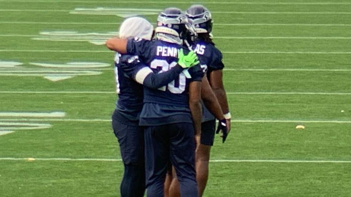 Rashaad Penny (20) hugs fellow running back Alex Collins (left) upon Penny’s return from the injured-reserve list to Seahawks practice Thursday at team headquarters in Renton. Collins did not practice for Seattle’s game Monday against New Orleans. Collins started last weekend in Pittsburgh for lead back Chris Carson, who remains on injured reserve.