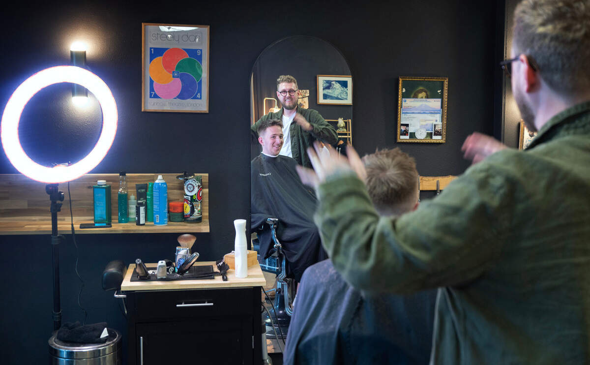 Owner Stewart Wentworth lets Cameron Vance of Port Orchard take a peek at his haircut at Black Cat Barbershop & Salon’s new location in Gig Harbor, Washington, on Tuesday, Nov. 7, 2023.