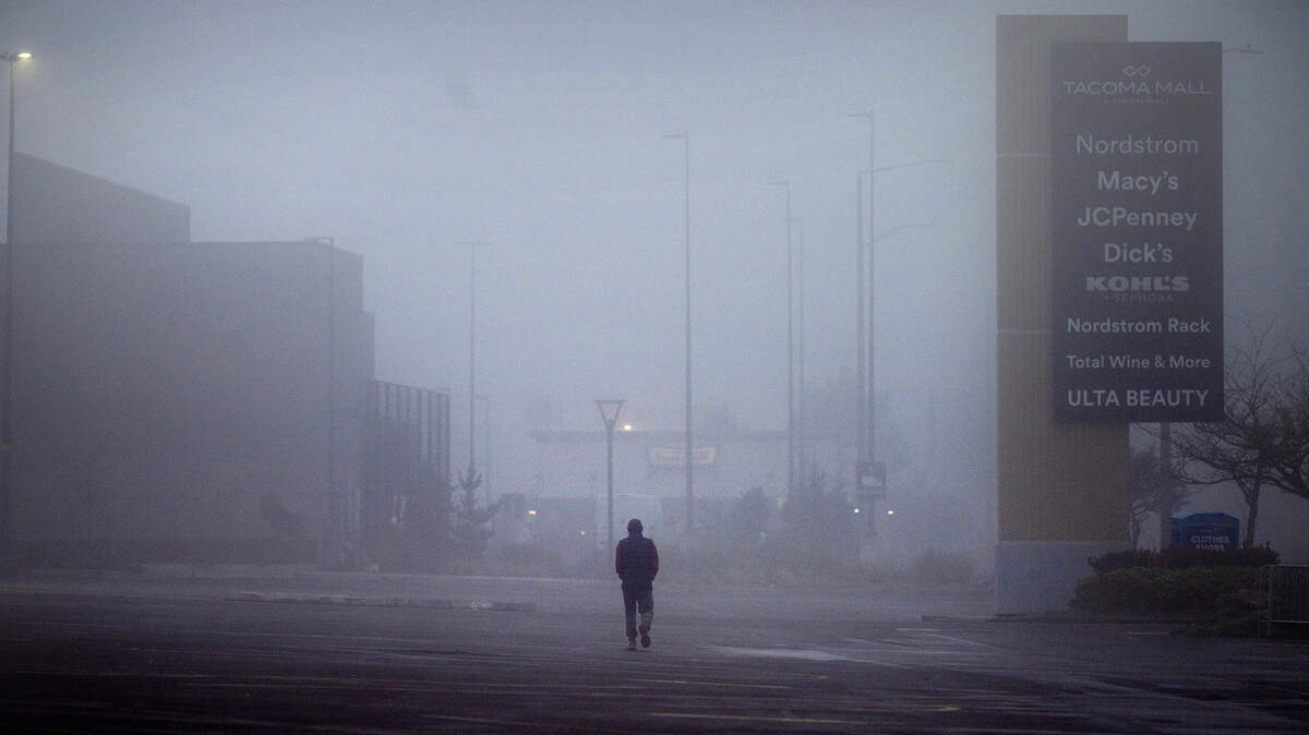 A man walks through the thick fog in the parking lot at the Tacoma Mall in Tacoma, Washington, on Friday, Dec. 15, 2023.
