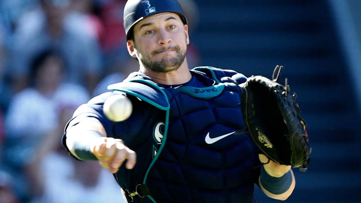 Seattle Mariners catcher Mike Zunino throws to first after Los Angeles Angels designated hitter Shohei Ohtani struck out swinging but got on base after a wild pitch during the eighth inning of a baseball game in Anaheim, Calif., Sunday, Sept. 16, 2018. (AP Photo/Alex Gallardo)