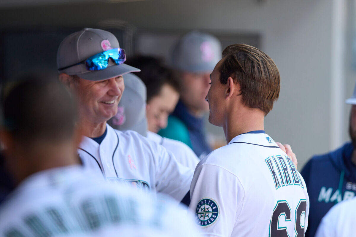 Seattle Mariners manager Scott Servais, left, talks with starting pitcher George Kirby, right, in the dugout after completing the sixth inning against the Tampa Bay Rays during a baseball game, Sunday, May 8, 2022, in Seattle. (AP Photo/John Froschauer)