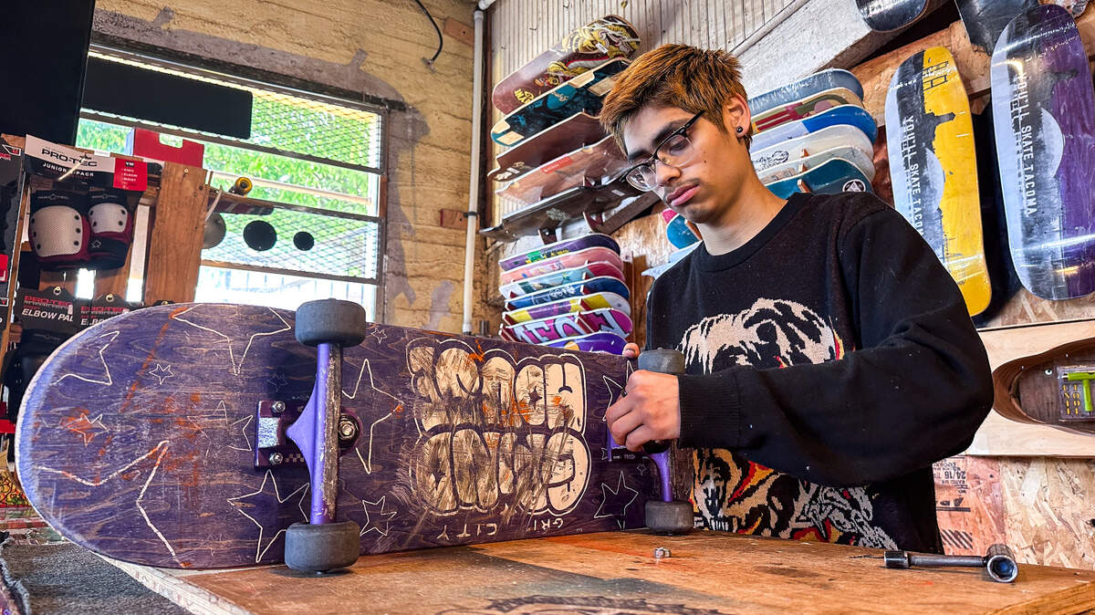 Alejandro Fernandez, 19, adds trucks to a skateboard at the Alchemy Skateboarding shop in Tacoma on June 21, 2022. Alchemy Skateboarding will host their annual Go Skate Tacoma event this Saturday.
