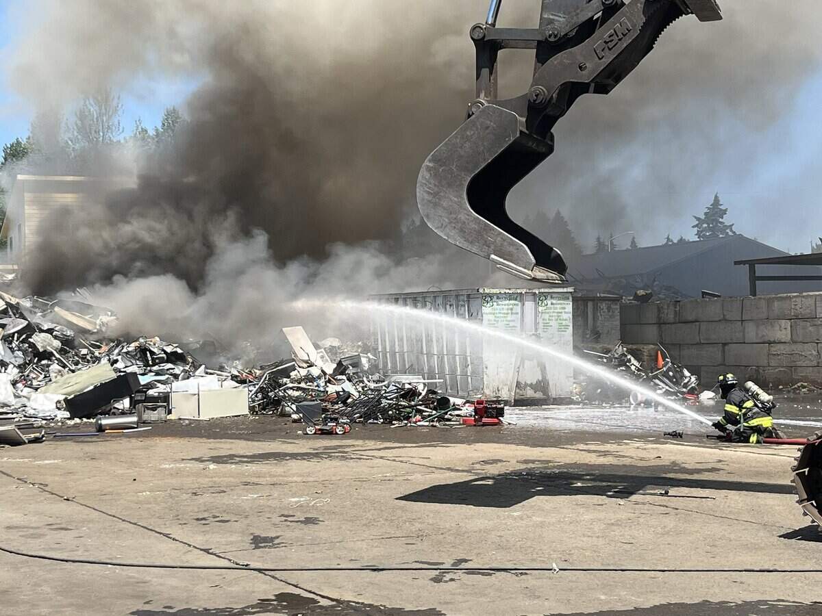 Central Pierce Fire & Rescue crews are putting out flames in a large debris pile at a recycling plant on Friday.