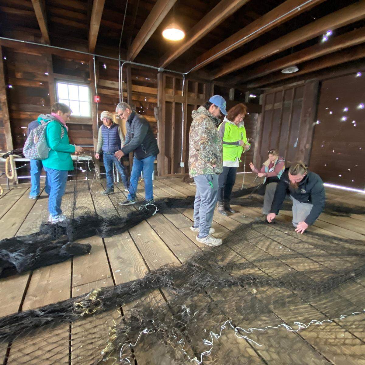 Participants of Gig Harbor BoatShop’s “Crew School,” a commercial fishing crew training program at Ancich Netshed, are introduced to net mending and repair.