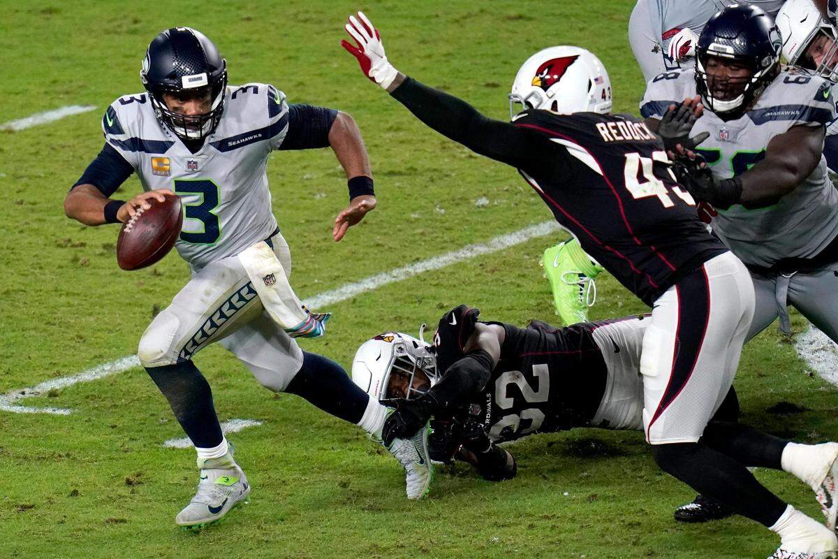 Seattle Seahawks quarterback Russell Wilson (3) escapes the reach of Arizona Cardinals strong safety Budda Baker (32) as outside linebacker Haason Reddick (43) pursues during the second half of an NFL football game, Sunday, Oct. 25, 2020, in Glendale, Ariz. (AP Photo/Ross D. Franklin)