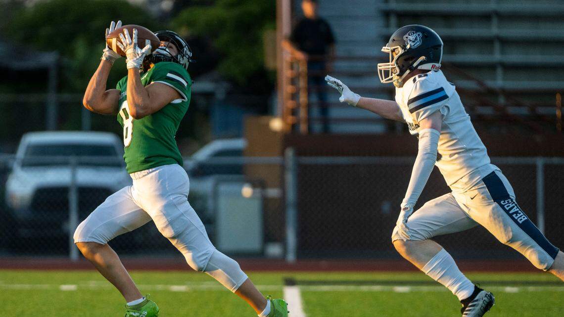 Emerald Ridge receiver Gio Kafentzis catches a pass from quarterback Jake Schakel as Olympia defensive back Blake Peterson defends during the first quarter of a 4A SPSL game at Sparks Stadium on Thursday, Sept. 8, 2022, in Puyallup, Wash.
