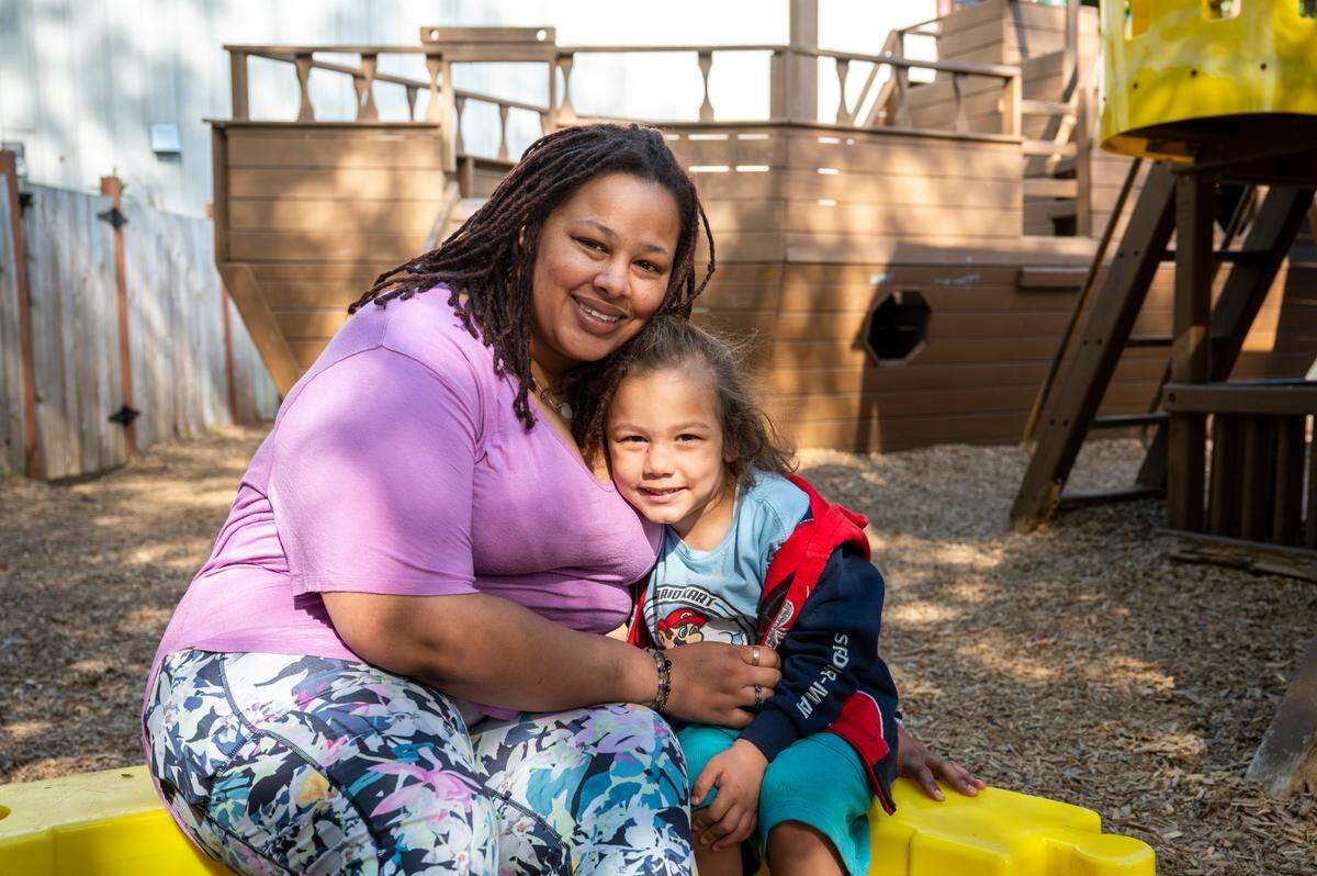Ayesha Williams, left, and son Jeremy, 4, sit for a photo at one of the Multicultural Child and Family Hope Center’s playgrounds on Friday, May 9, 2025, in Tacoma. Three of Williams’ four children have taken part in the Head Start program, and all four continue to go to school at the center.