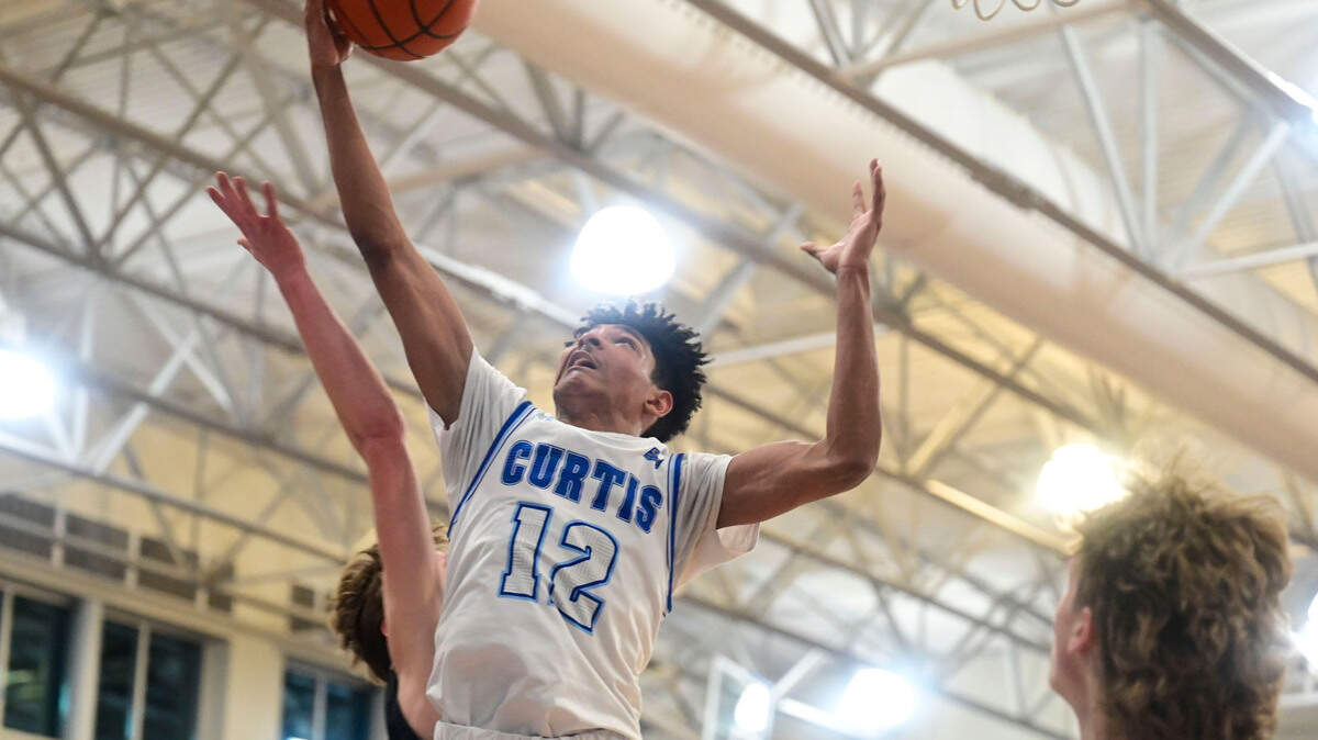 Curtis guard Cinque Maxwell (12) pulls down a rebound from Union guard Porter Hill (20) during the second quarter of a District 3/4 4A semifinal game on Friday, Feb. 17, 2022, at Curtis High School in University Place, Wash.