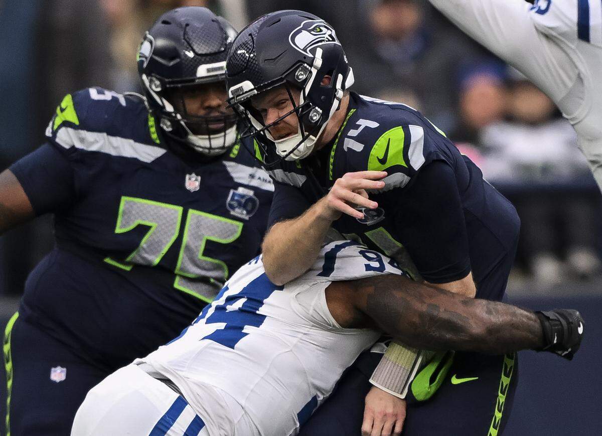 Indianapolis Colts defensive end Tyquan Lewis (94) hits Seattle Seahawks quarterback Sam Darnold (14) as he throws during the third quarter of the game at Lumen Field, on Sunday, Dec. 14, 2025, in Seattle.