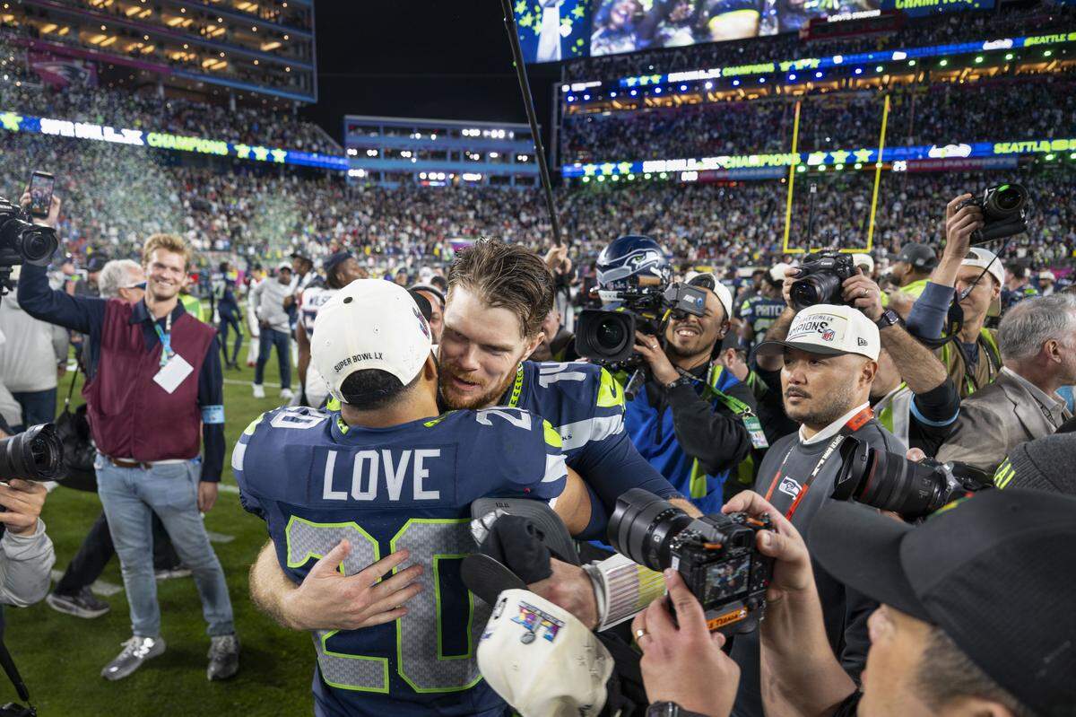 Seattle Seahawks safety Julian Love (20) and quarterback Sam Darnold (14) hug after beating the New England Patriots, 29-13, in Super Bowl LX at Levi's Stadium on Feb. 8, 2026 in Santa Clara, Calif.