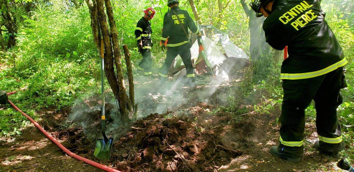 Central Pierce Fire & Rescue crews work to extinguish burning brush in August in an area near Charlotte’s Blueberry Park in Tacoma.