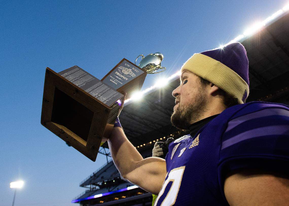 Washington Huskies quarterback Jacob Eason (10) holds up the Apple Cup after the game. The Washington Huskies played the Washington State Cougars in the Apple Cup at Husky Stadium in Seattle, Wash., on Friday, Nov. 29, 2019.