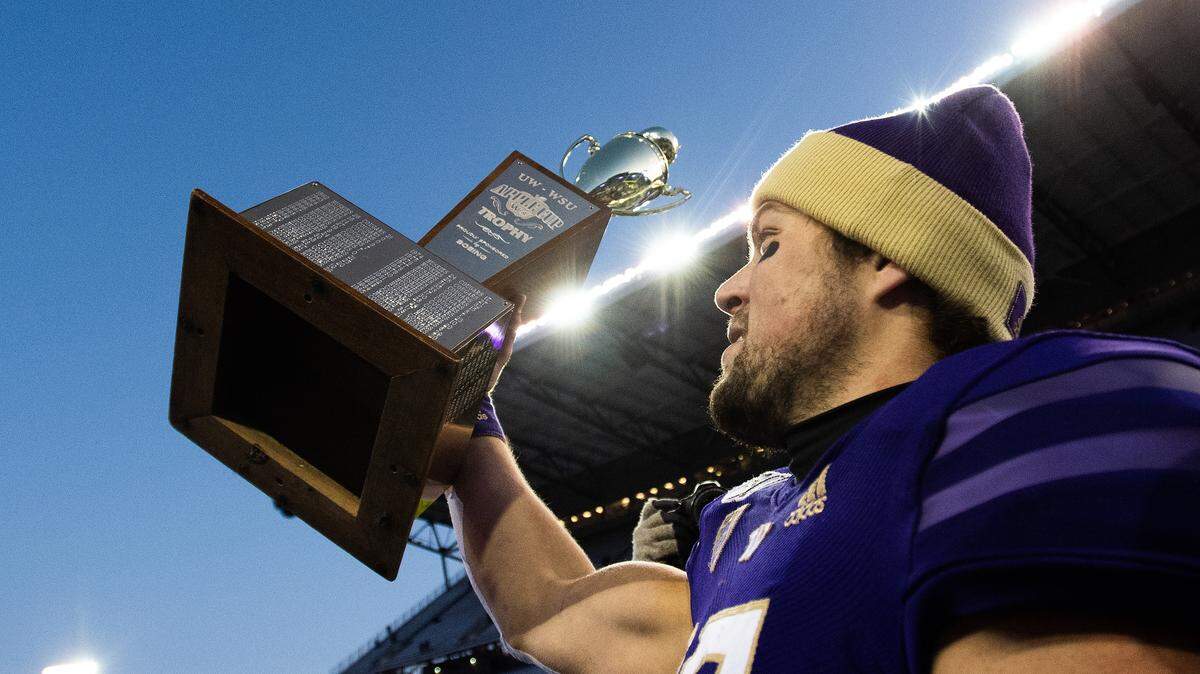 Washington Huskies quarterback Jacob Eason (10) holds up the Apple Cup after the game. The Washington Huskies played the Washington State Cougars in the Apple Cup at Husky Stadium in Seattle, Wash., on Friday, Nov. 29, 2019.