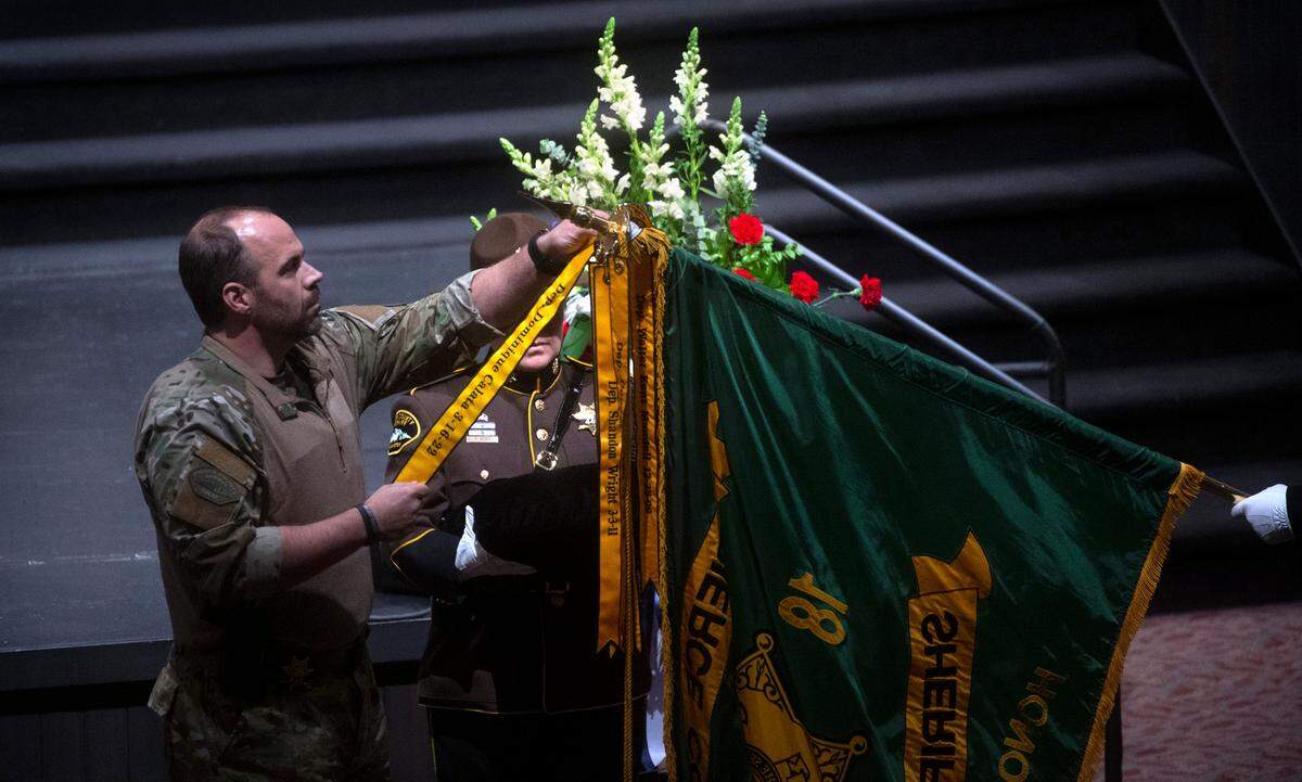 A fallen-officer ribbon remembering deputy Dom Calata is added to the Pierce County Sheriff’s Department flag during the celebration of life ceremony at Church For All Nations in Parkland, Washington, on Friday, March 25, 2022.