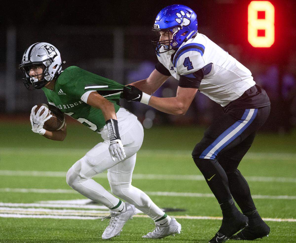 Emerald Ridge wide receiver Tony Harste tries to break away from Bothell linebacker Mingo Lemley during Friday night’s 4A district football game at Sparks Stadium in Puyallup, Washington, on Nov. 3, 2023. Emerald Ridge won the game, 50-36.
