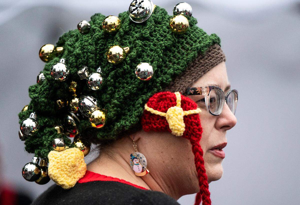 A woman wears a festive hat covered in bells at the 5th Annual Christmas Eve Ugly Sweater 5K on the Nathan Chapman Memorial Trail in Puyallup, Wash. on Dec. 24, 2022.