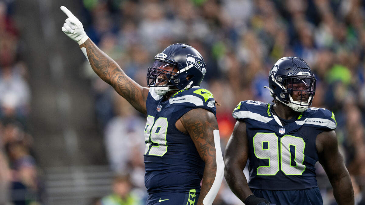 Seattle Seahawks defensive end Leonard Williams (99) and defensive tackle Jarran Reed (90) react to a defensive stop against the Cleveland Browns during the first quarter of the preseason game at Lumen Field, on Saturday, Aug. 24, 2024 in Seattle, Wash.