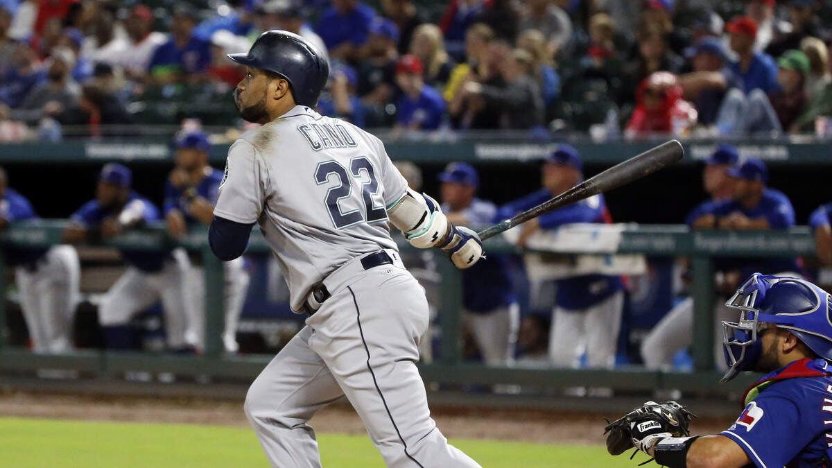 Seattle Mariners’ Robinson Cano (22) watches the flight of his three-run home run against the Texas Rangers during the fifth inning of a baseball game Saturday, Sept. 22, 2018, in Arlington, Texas. (AP Photo/Michael Ainsworth)