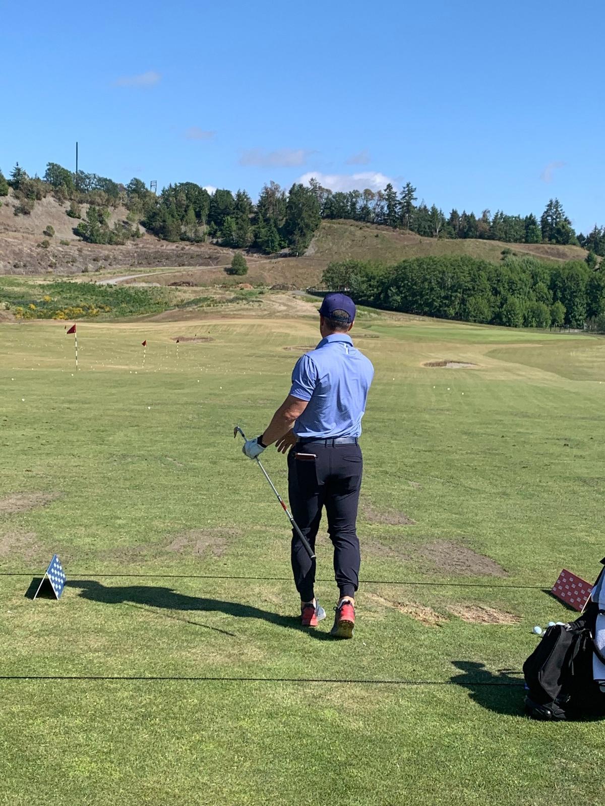 Danny Woodhead watches another drive go down the Chambers Bay practice range before the start of the U.S. Amateur Four-Ball Championship.