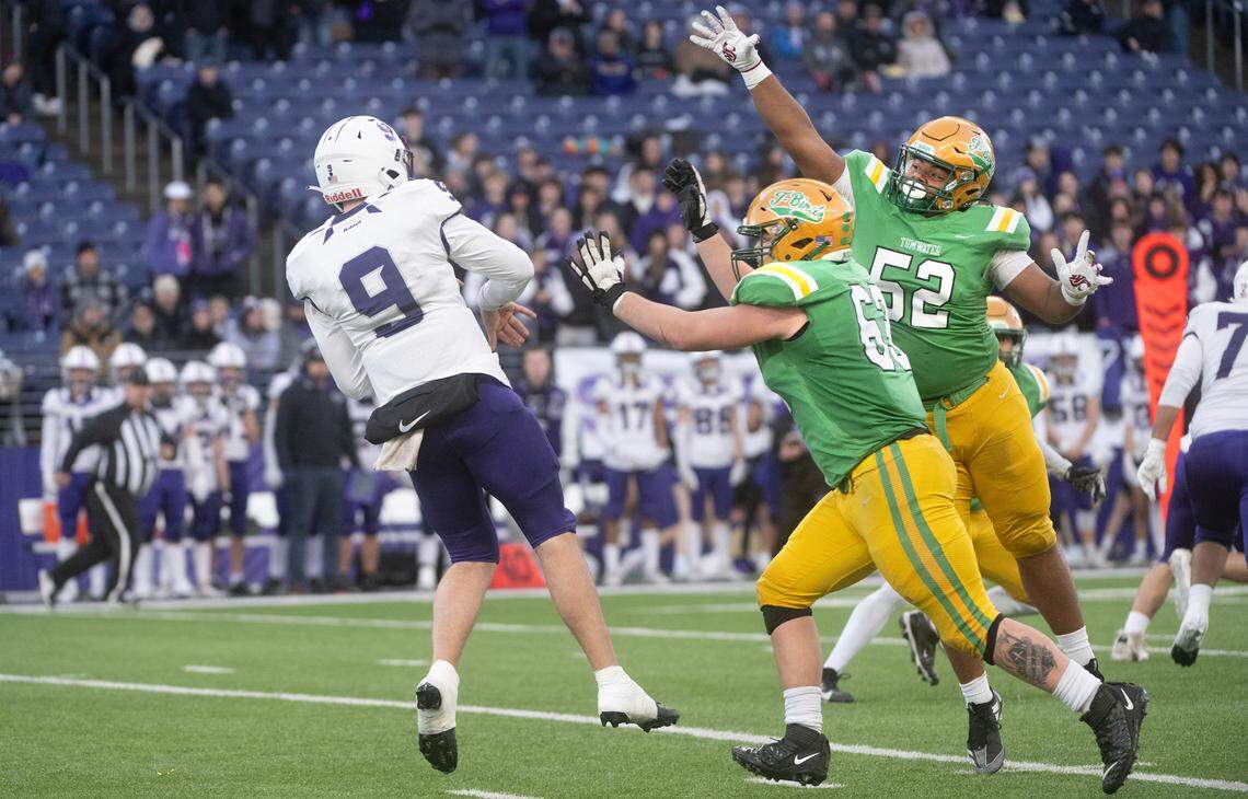 Tumwater defensive linemen Dylan Gilliland and Malijah Tucker (52) pressures Anacortes quarterback Ryan Harrington during Saturday’s WIAA 2A state football championship game at Husky Stadium in Seattle, Washington, on Dec. 7, 2024. Anacortes won the game, 20-10.