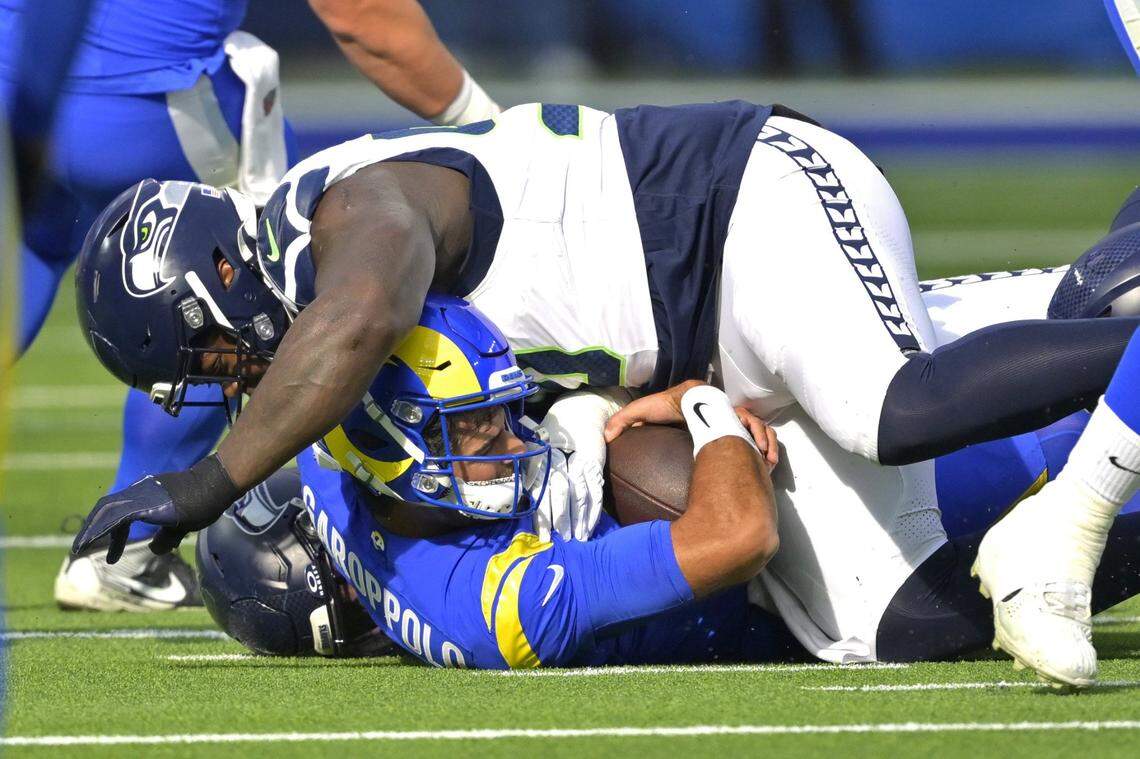 Jan 5, 2025; Inglewood, California, USA; Los Angeles Rams quarterback Jimmy Garoppolo (11) is sacked by Seattle Seahawks defensive tackle Roy Robertson-Harris (98) in the first half at SoFi Stadium. Mandatory Credit: Jayne Kamin-Oncea-Imagn Images