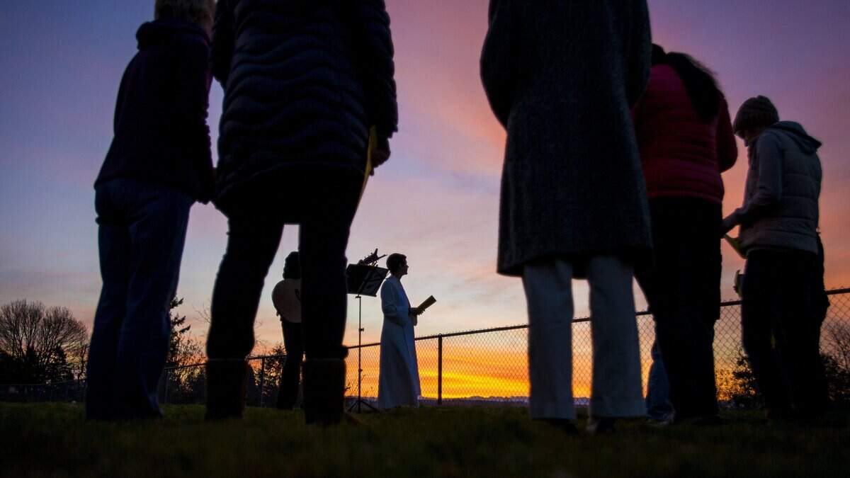 Pastor Sarah Wyles, center, looks out over Commencement Bay as she leads an outdoor Easter sunrise service in Tacoma, on Sunday, April 16, 2017. Gateway columnist Alfred Gunn writes that Easter is a time of redemption.