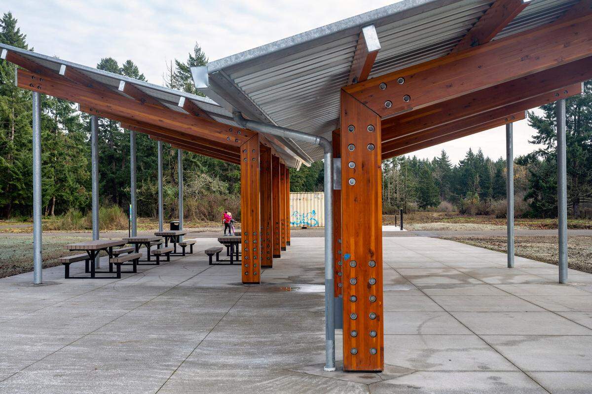 People walk past a new covered picnic area at Swan Lake Park on Friday in Tacoma.
