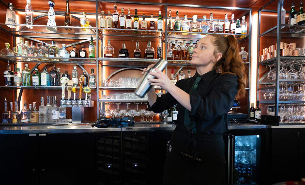 Bar manager Briana Sayler prepares a gin martini at Toscano’s on Tuesday, Sept. 24, 2024. Staff wears crisp black uniforms and tables are lined with white linens, which makes the restaurant feel fancy, but said Walker, “We want people to come as they are.”